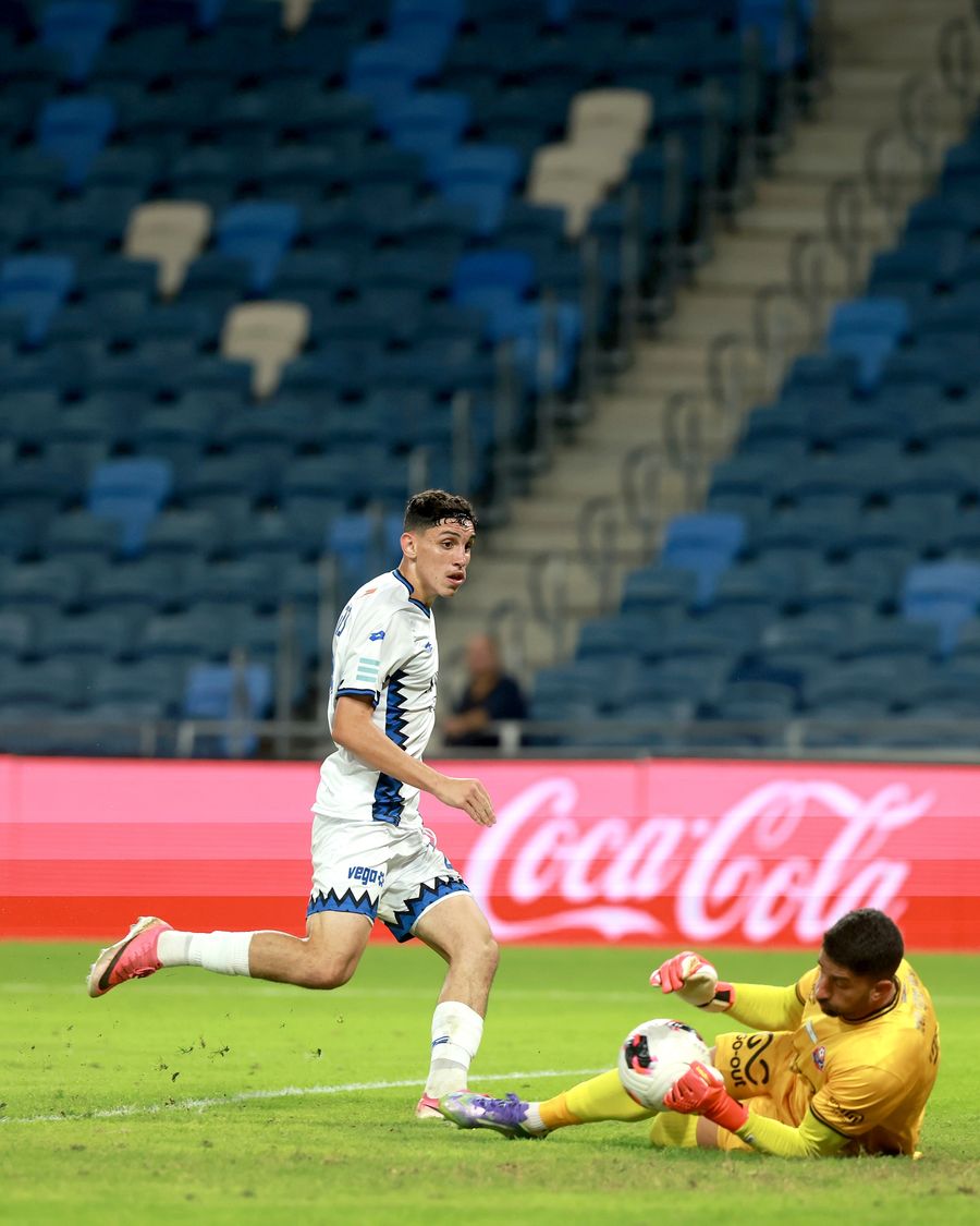 A footballer dives to block the ball